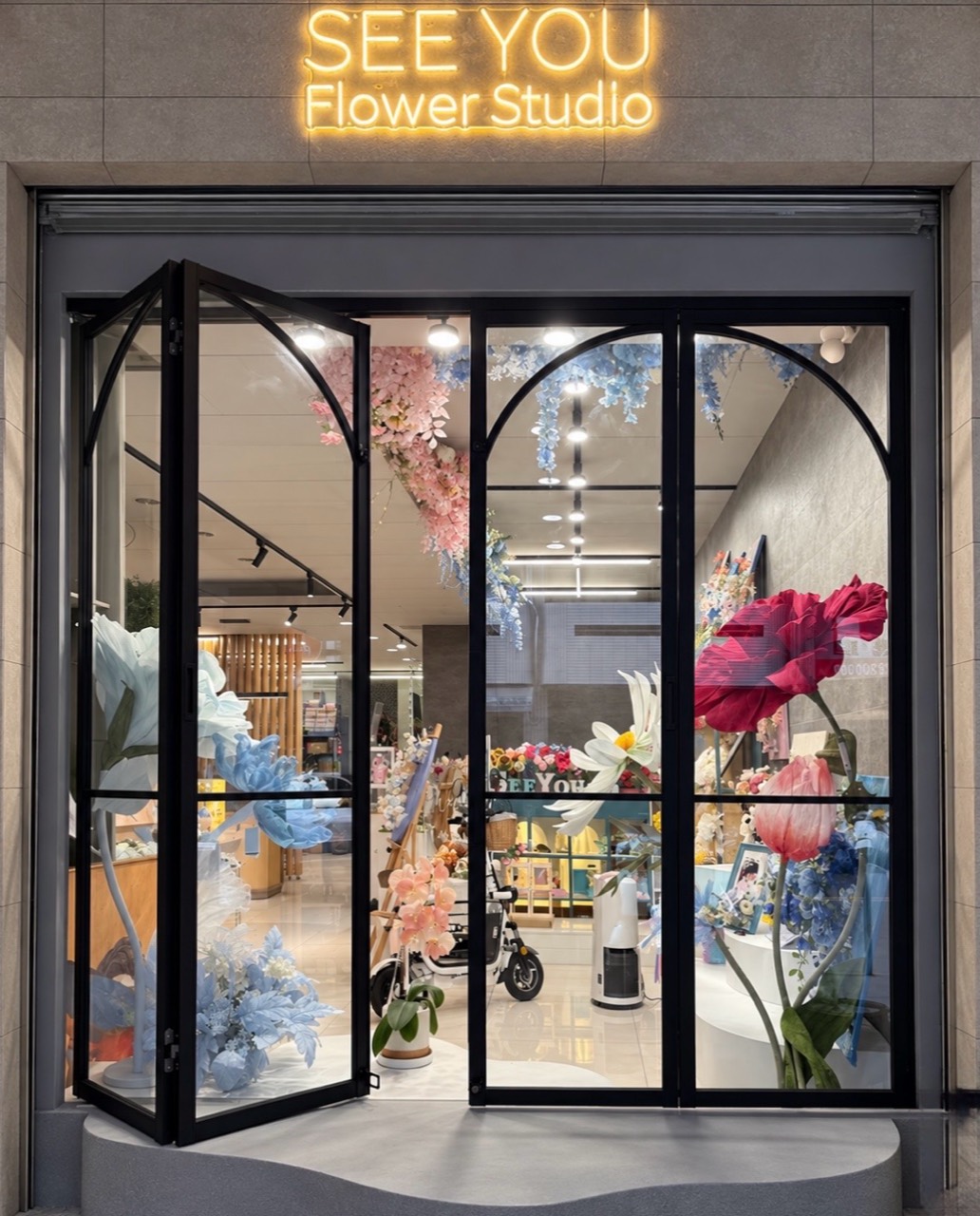 SeeYou Flower 門市外觀:發光招牌、黑色拱門與店內巨型花藝